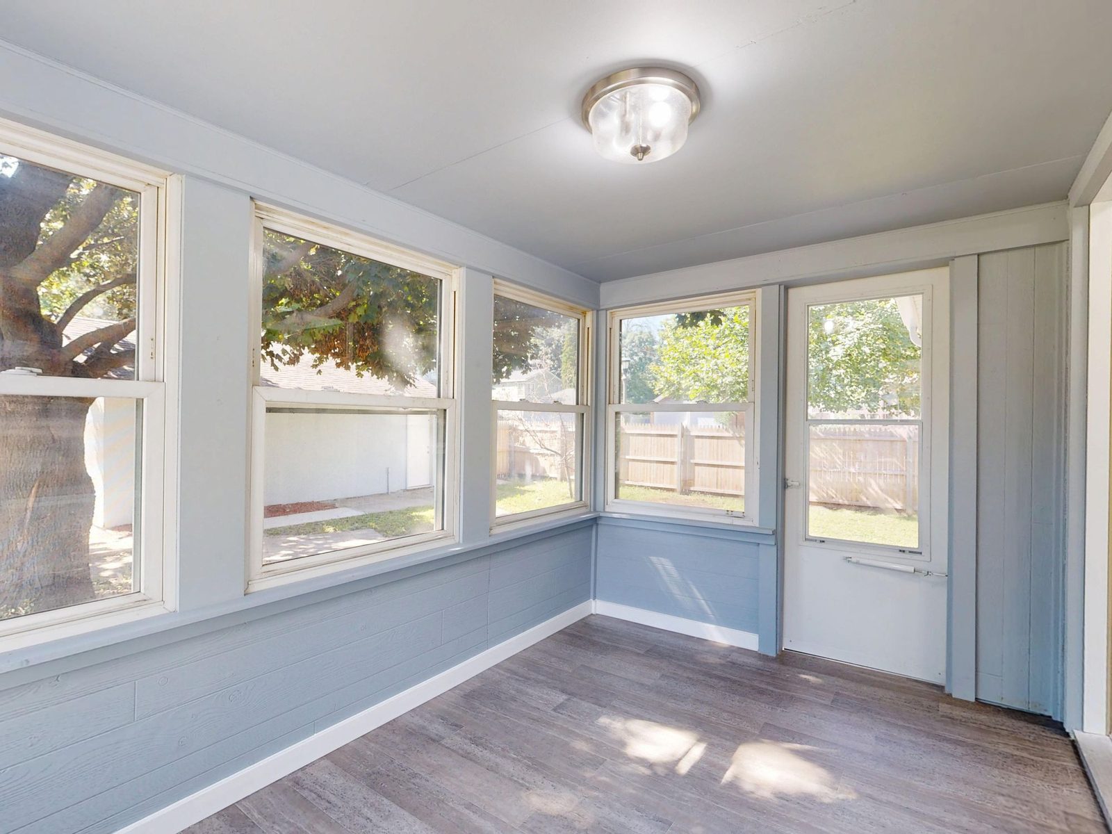 Bright sunroom conservatory interior with large windows and a solid ceiling
